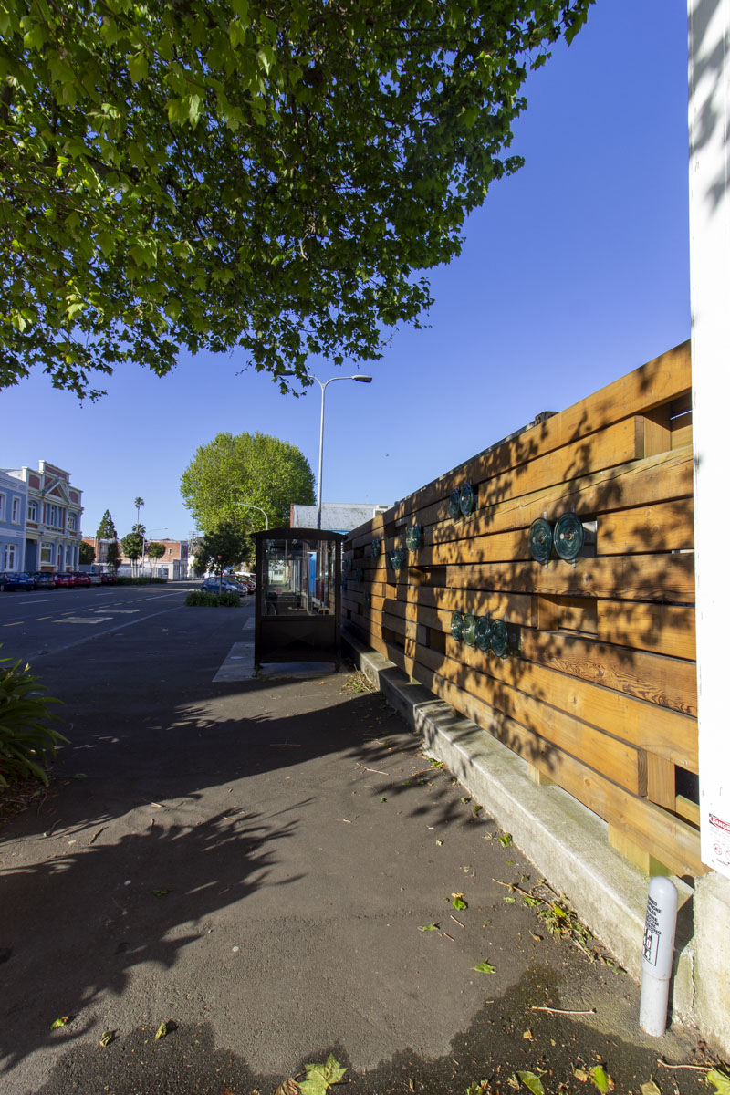 Tram shed fence at dusk with new bus stop.