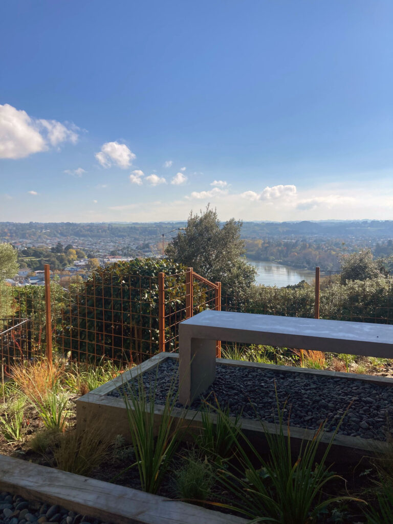 The garden at The Mantles, Dalgleish Architects award winning home, with a seat and view of the Whanganui River. 